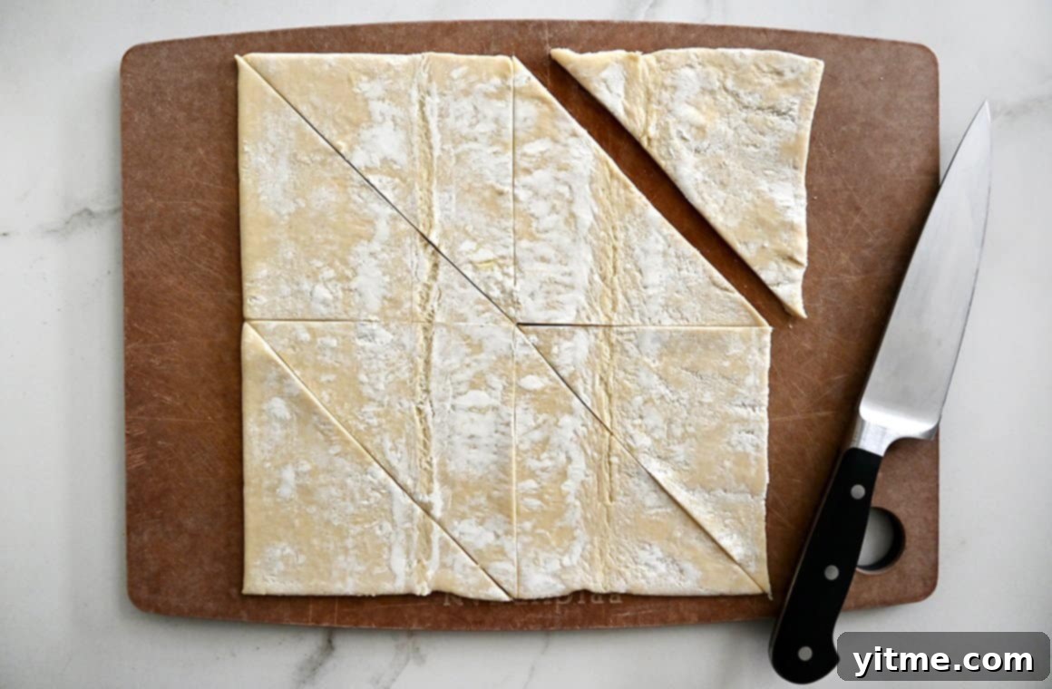Raspberry Cream Cheese Danish 4 Store-bought puff pastry on a wood cutting board with a sharp knife