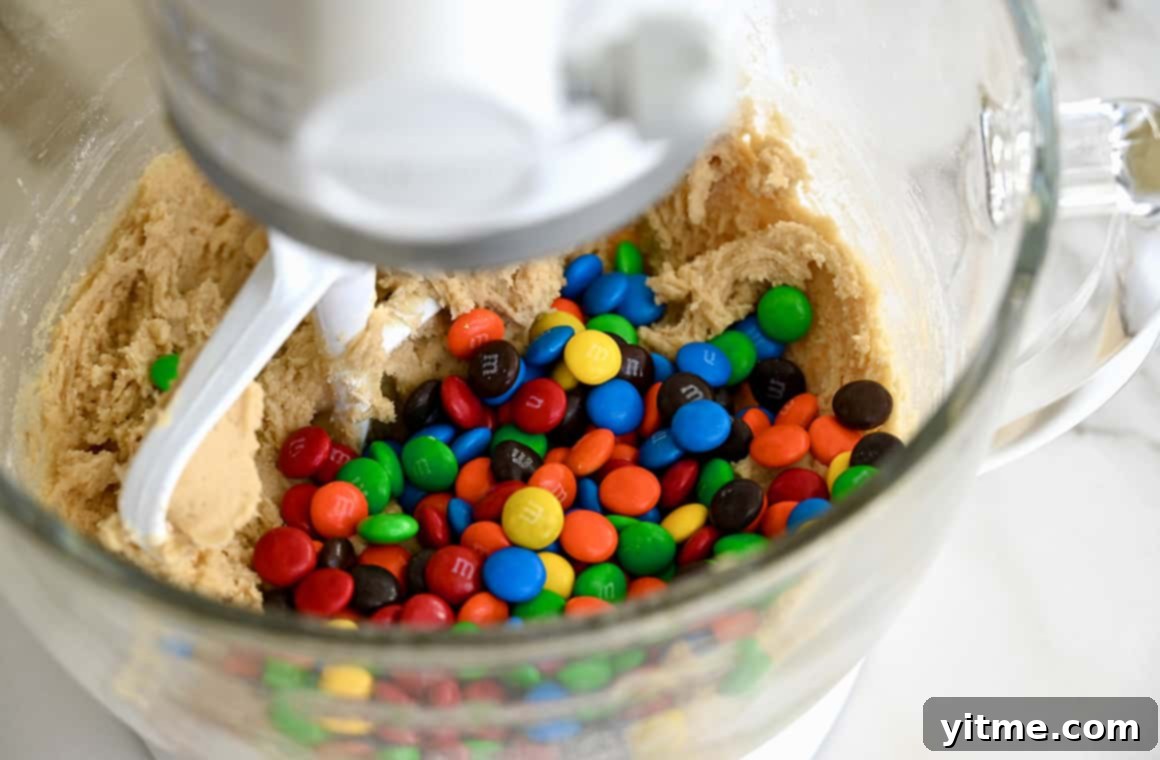 M&M's Soft Cookie Delights 3 Dough with rainbow-colored candy-coated chocolates in a stand mixer bowl