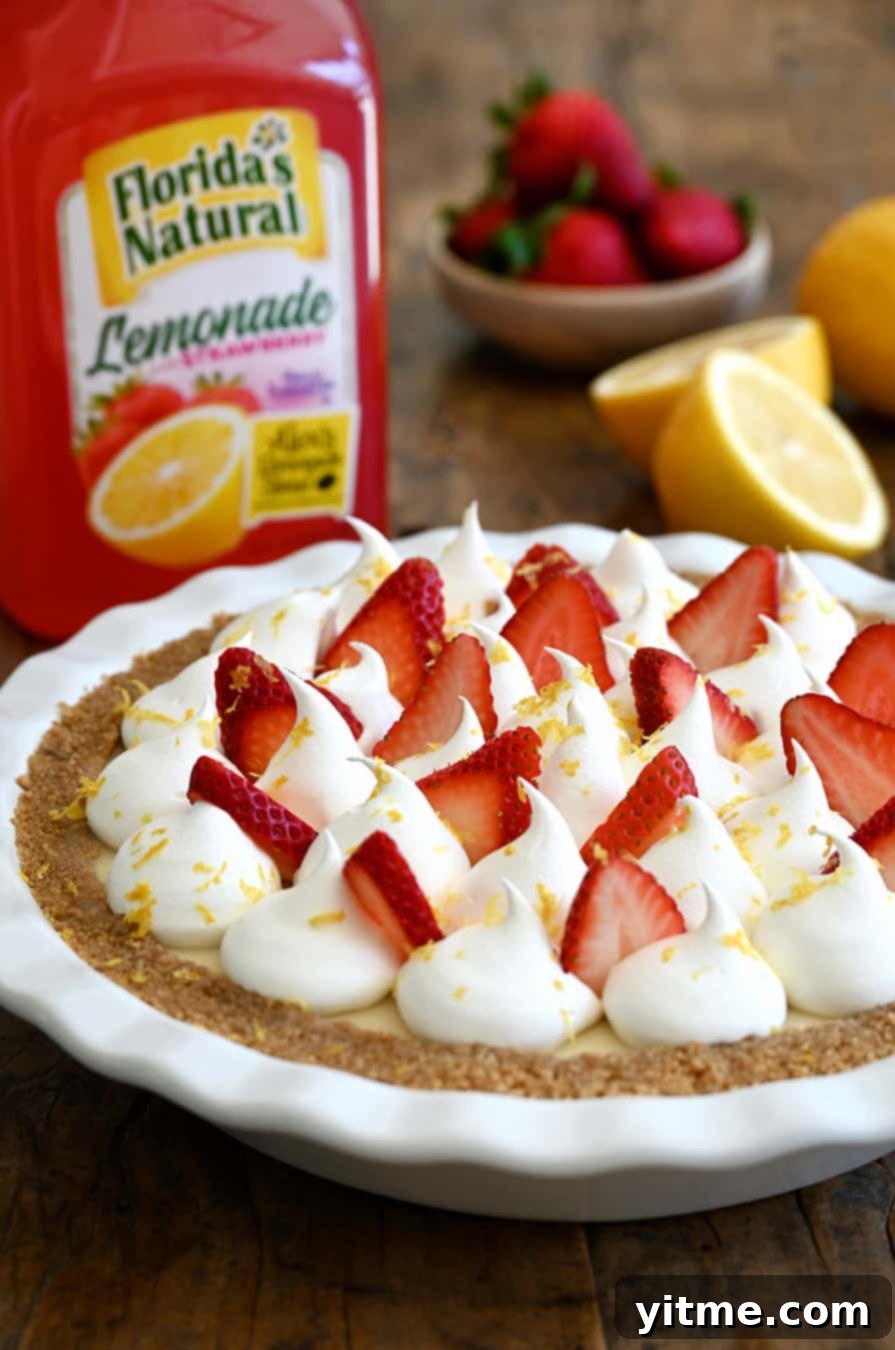 A beautifully sliced Strawberry Lemon Icebox Pie with a full bottle of Florida's Natural Strawberry Lemonade in the background