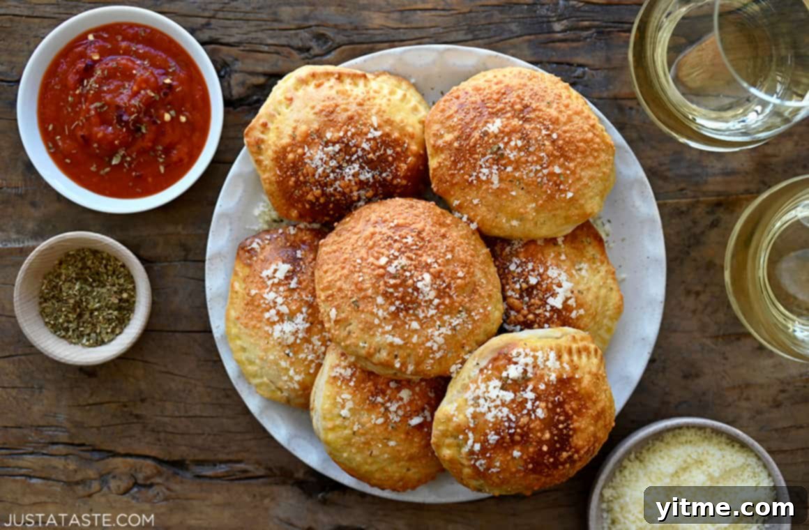 A beautifully arranged plate of air fryer pizza pockets, garnished with fresh basil, surrounded by dipping bowls of marinara sauce and grated Parmesan cheese, with glasses of wine in the background, suggesting a perfect meal.
