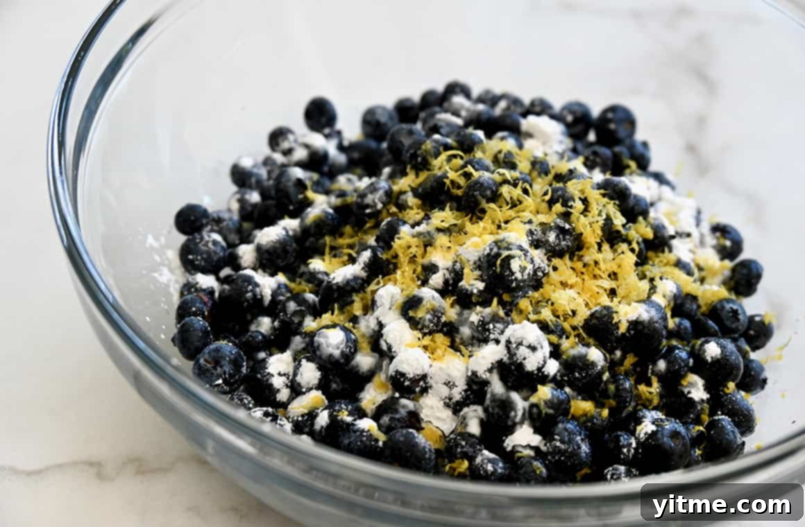 Rustic Blueberry Tart with Honey-Thyme Drizzle 4 Clear bowl showcasing fresh blueberries, cornstarch, and lemon zest.