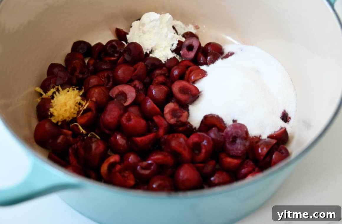 Streusel-Topped Cherry Pie Bites 3 A large saucepan containing fresh cherries, sugar, cornstarch, vanilla extract, and lemon zest ready to be cooked into a cherry pie filling.