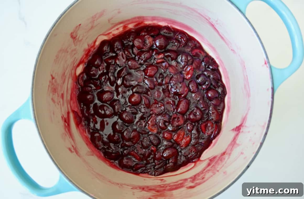 Streusel-Topped Cherry Pie Bites 4 A top-down view of fresh cherry pie filling simmering in a large saucepan, creating a thick and luscious mixture.