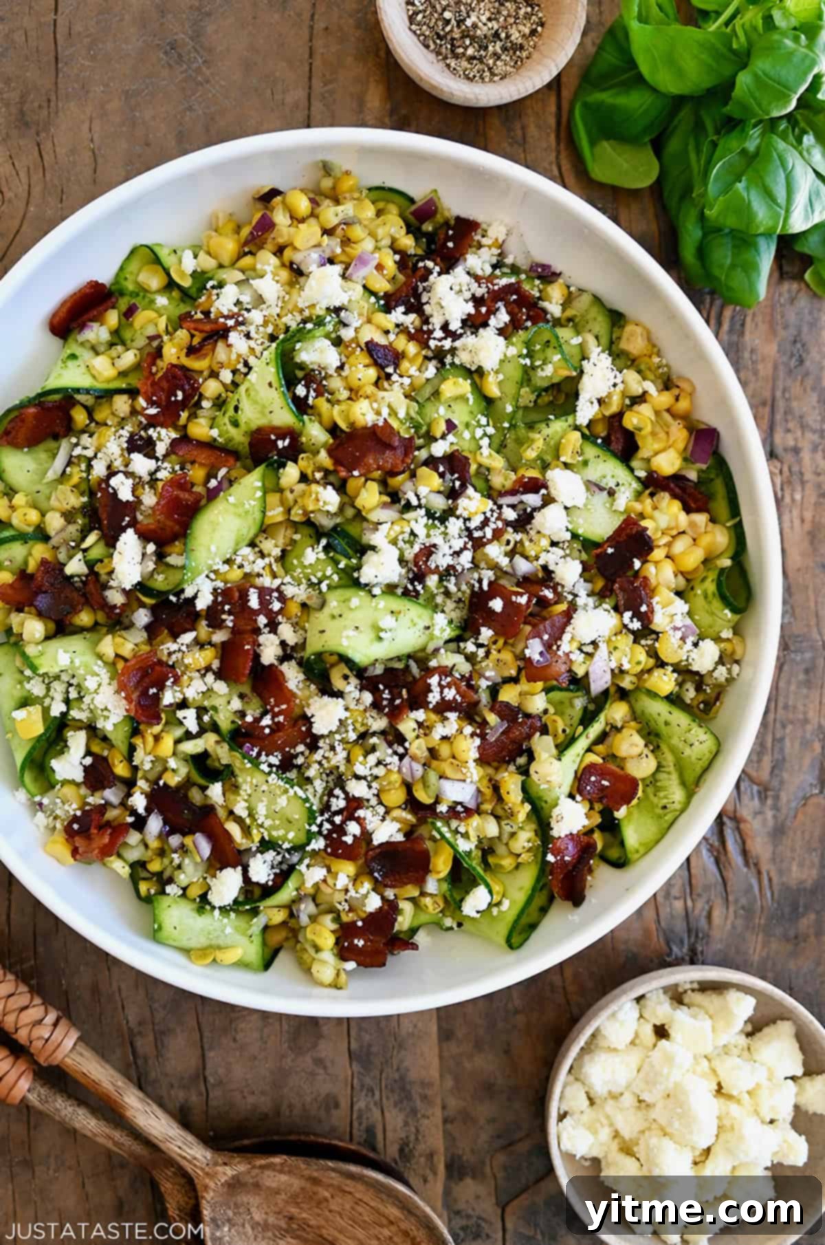 Zucchini and corn salad topped with crispy bacon and cotija cheese.