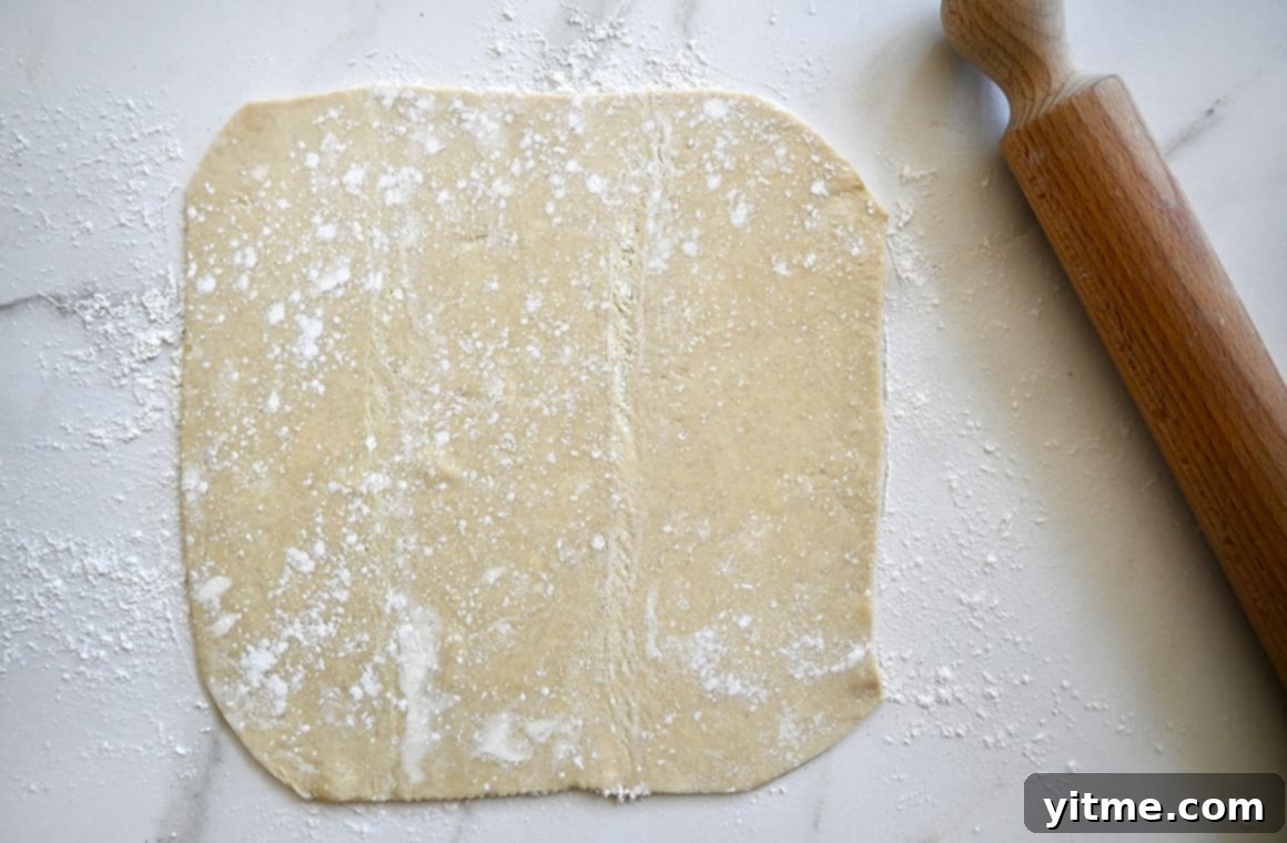 Puff Pastry Galette: A Simple Guide 3 Puff pastry sheet on a floured surface with a rolling pin
