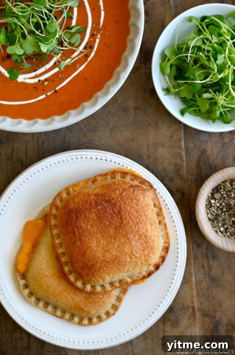 Air Fryer Grilled Cheese Perfection 2 Two air fryer grilled cheese sandwiches beside a bowl of tomato soup.