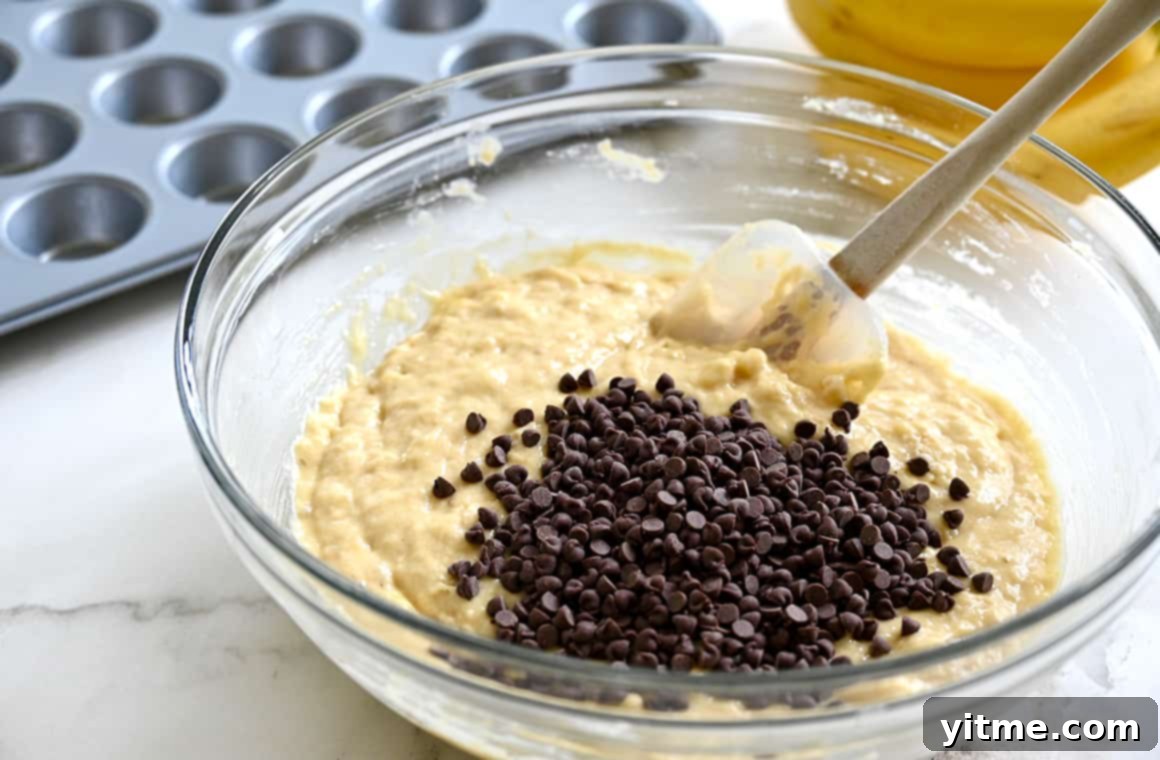 Batter with mini chocolate chips in a clear bowl