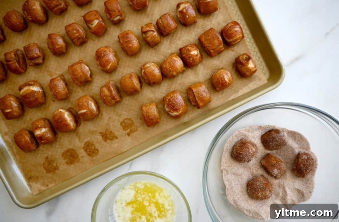 A top-down view of soft pretzels being tossed in a pumpkin spice and sugar mixture next to a baking sheet topped with soft pretzels