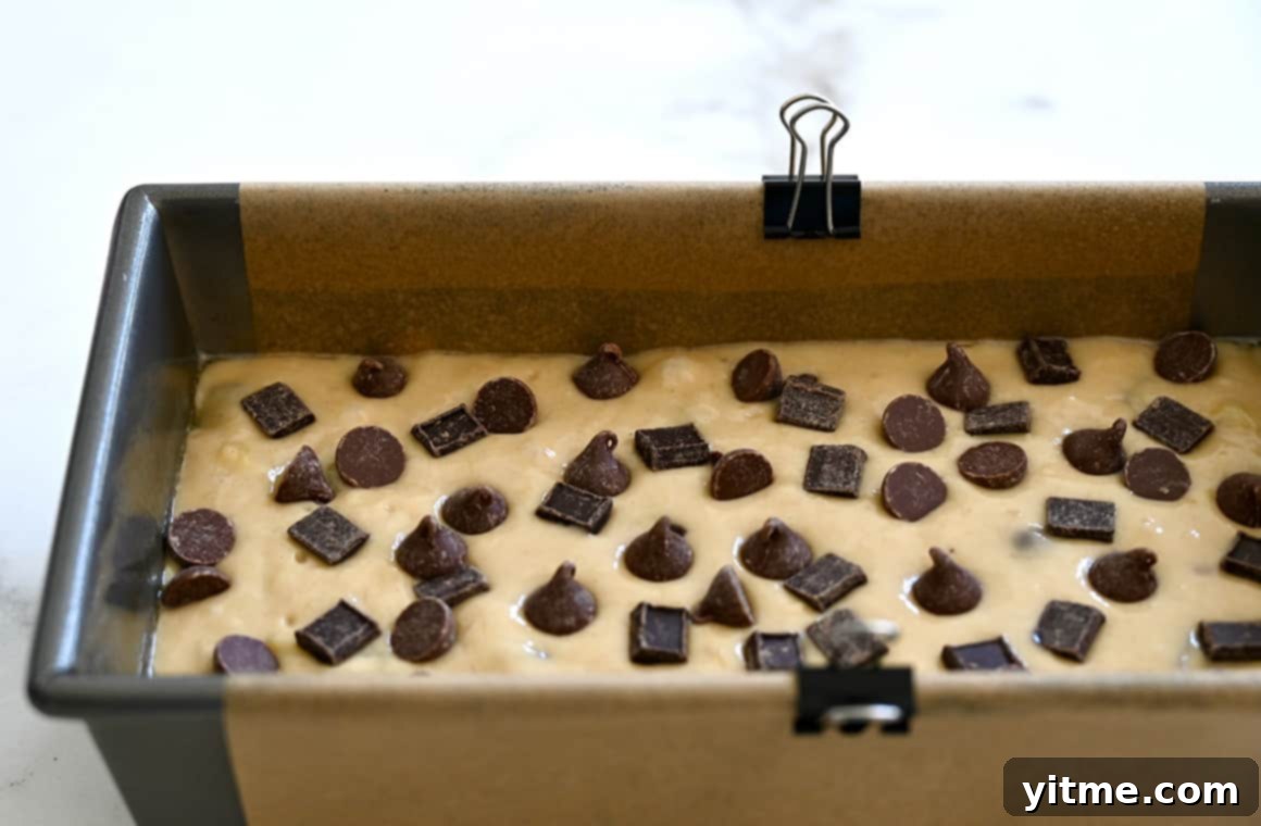 A loaf pan lined with parchment paper secured with metal paper clips