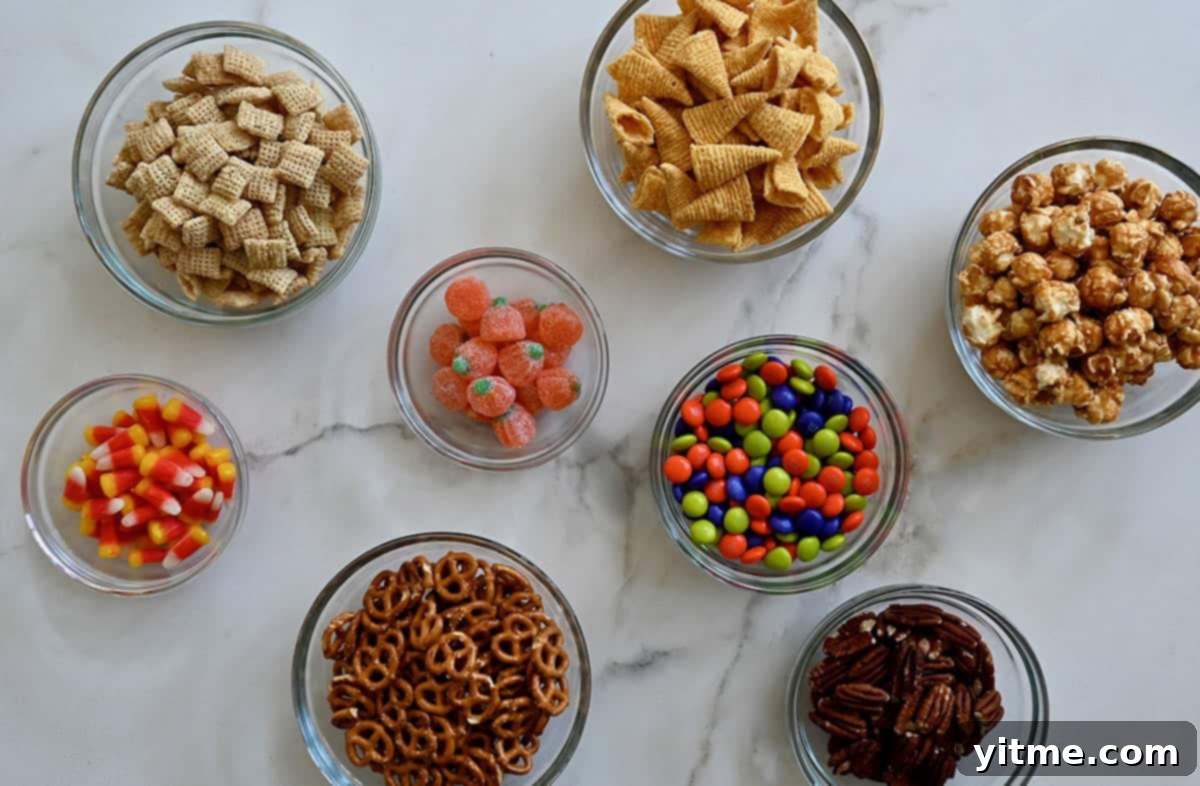 Glass bowls containing sweet and salty snacks to make up a cereal party mix.