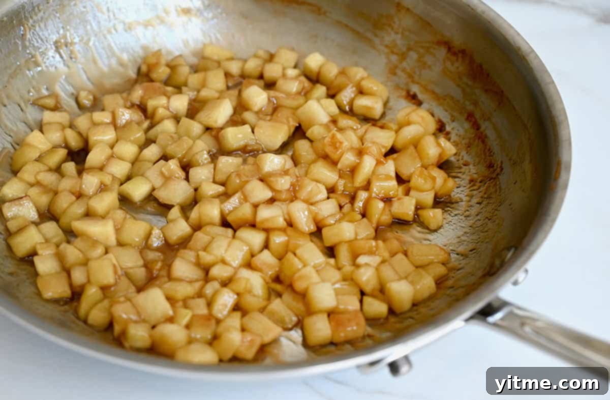 Caramel Apple Dessert Dip 3 Sautéed apples with caramel sauce in a skillet.