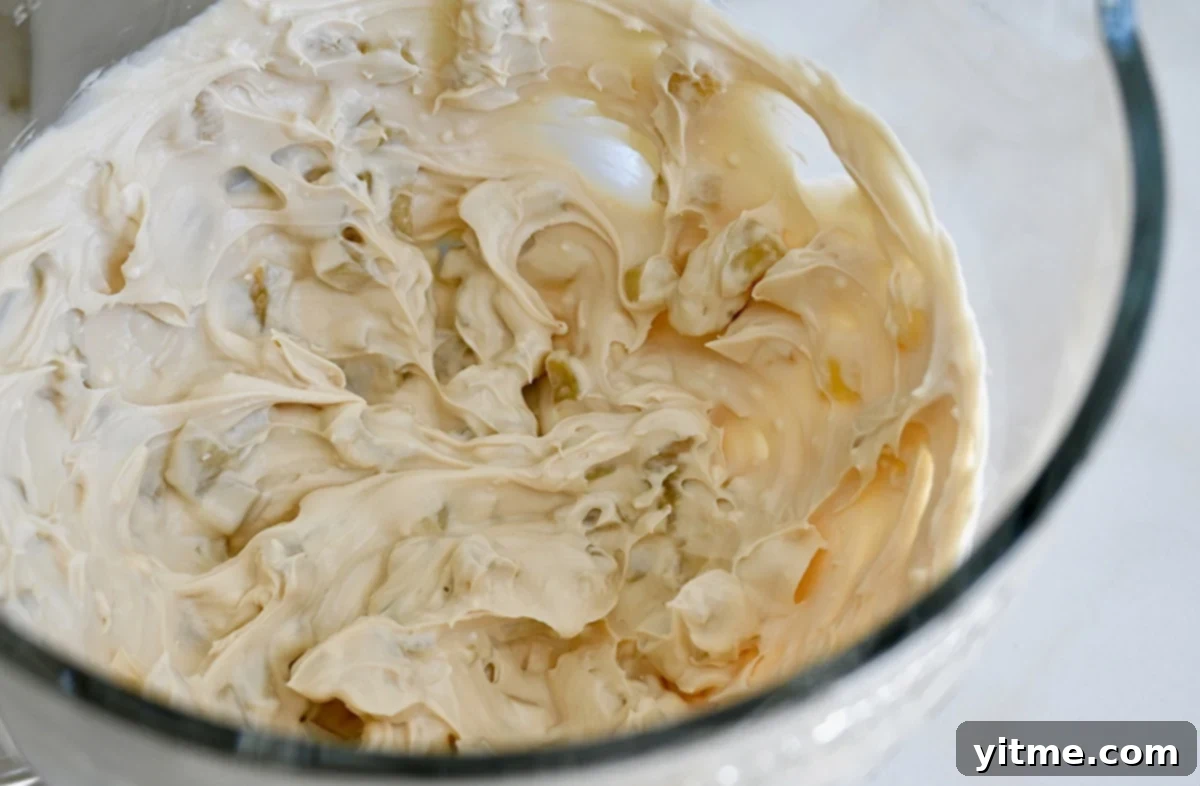 Caramel Apple Dessert Dip 4 Whipped cheesecake dip with sautéed apples in a mixing bowl.