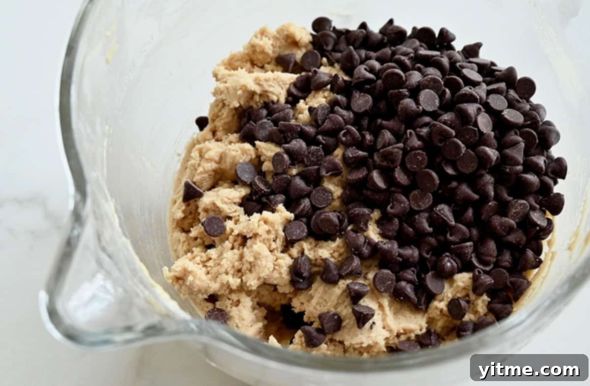 Chocolate chip cookie dough in a glass mixing bowl.