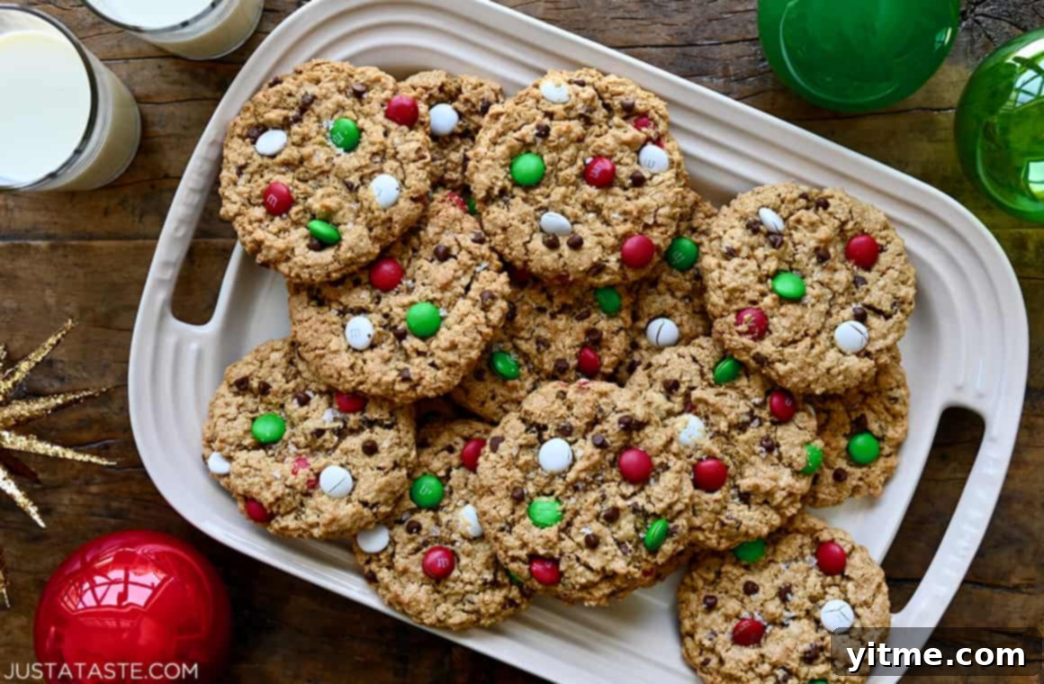 Soft and chewy Christmas Monster Cookies artfully arranged on a platter, accompanied by two glasses of cold milk, ready for a cozy holiday treat.