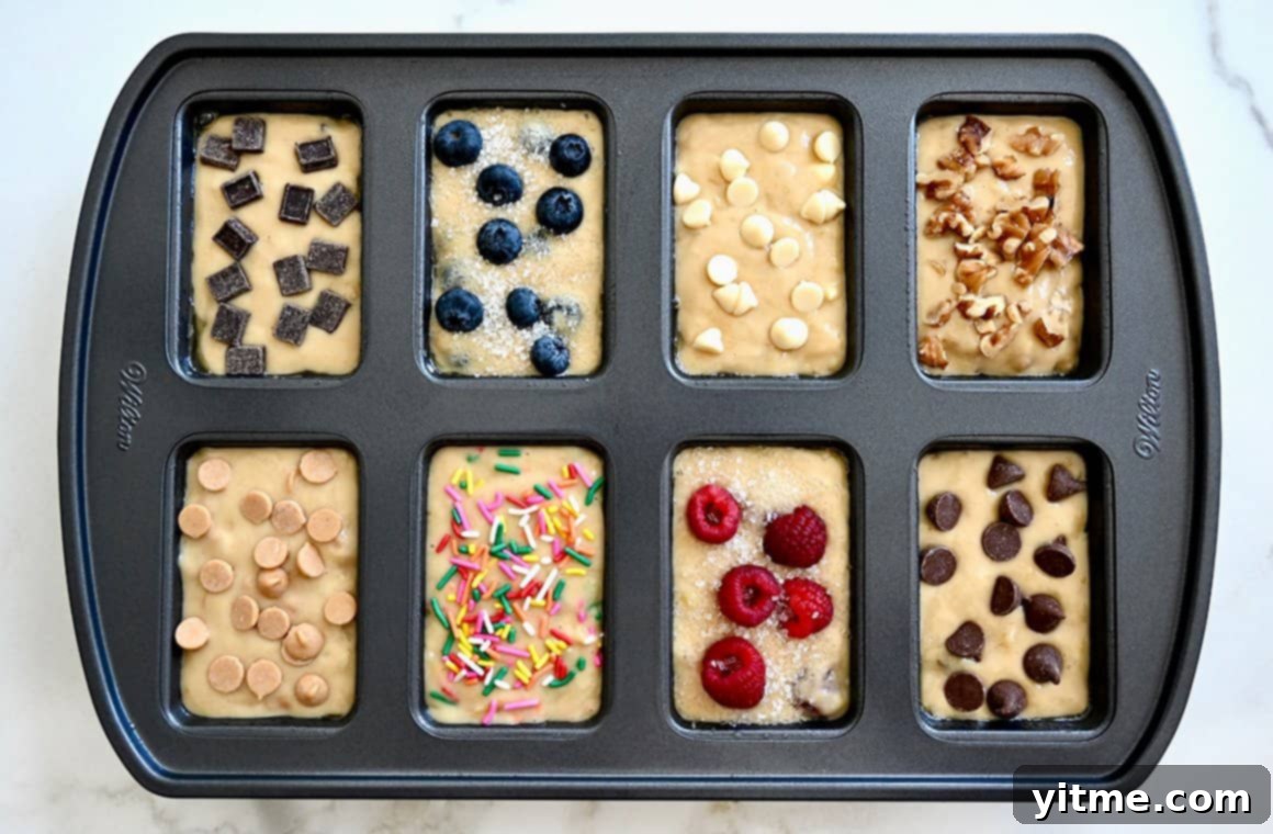 Mini Banana Bread Bites 4 An overhead shot of a mini loaf pan, each cavity filled with batter and uniquely topped with a variety of different toppings, showcasing the potential for creative customization.
