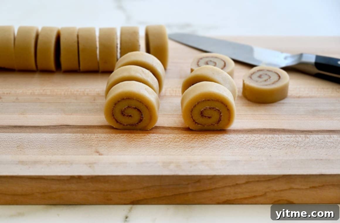Cinnamon Swirl Cookies 6 Slice-and-bake cookies on a cutting board with a sharp knife
