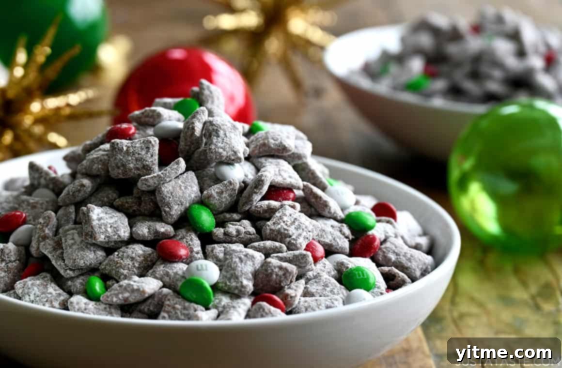 Yuletide Puppy Chow 7 Christmas Puppy Chow with festive red, green, and white M&Ms arranged in a white serving bowl, ready for a holiday gathering.