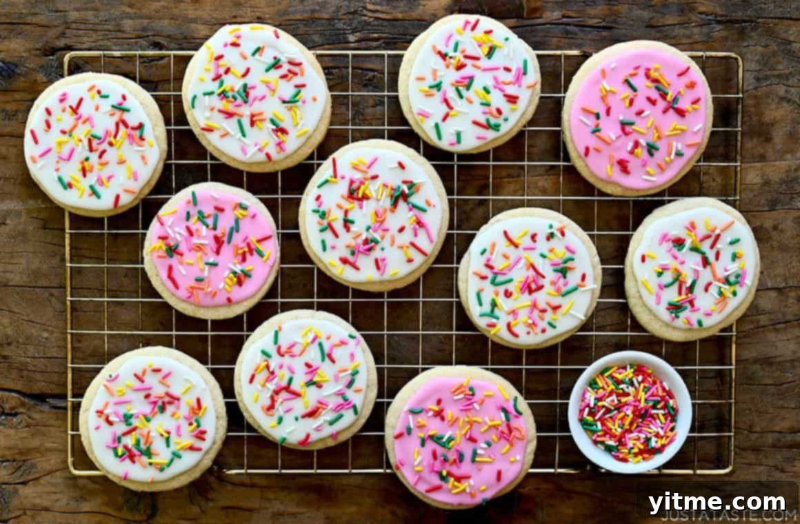 Silky Smooth Sugar Cookie Icing 7 Bakery-quality sugar cookies, beautifully adorned with colorful icing and rainbow sprinkles, resting on a cooling rack.