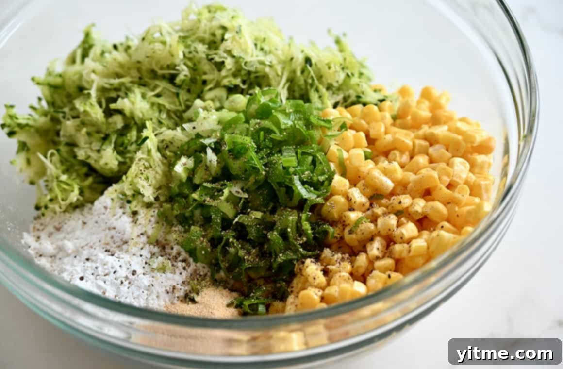 Baked or Air Fried Corn and Zucchini Fritters 4 A clear bowl containing corn kernels, finely grated zucchini, chopped scallions and flour