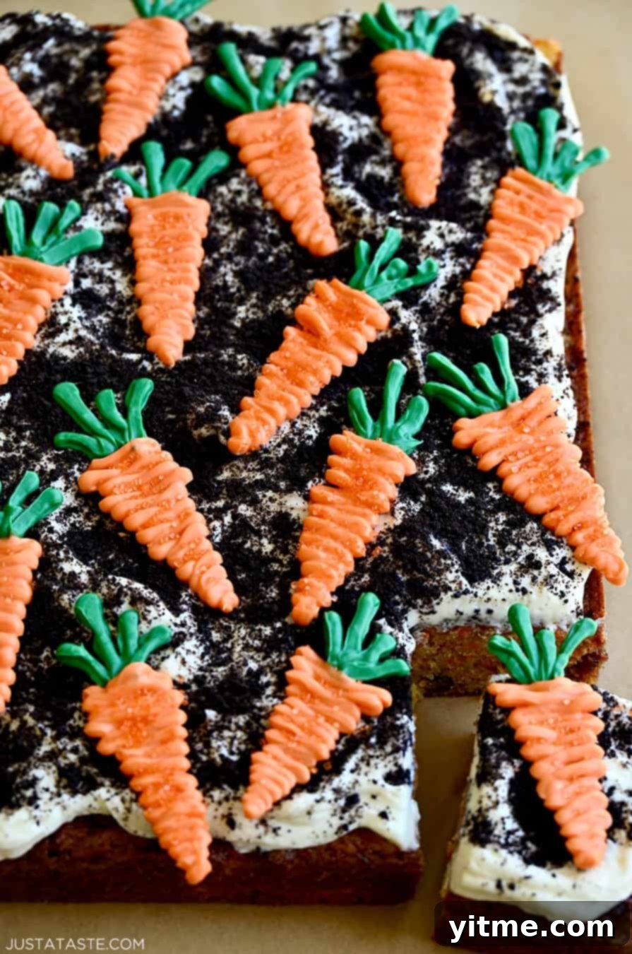 Zesty Carrot Cake Squares with Creamy Frosting 9 A corner slice of carrot sheet cake topped with cream cheese frosting, crushed Oreo "dirt," and candy melt "carrots"