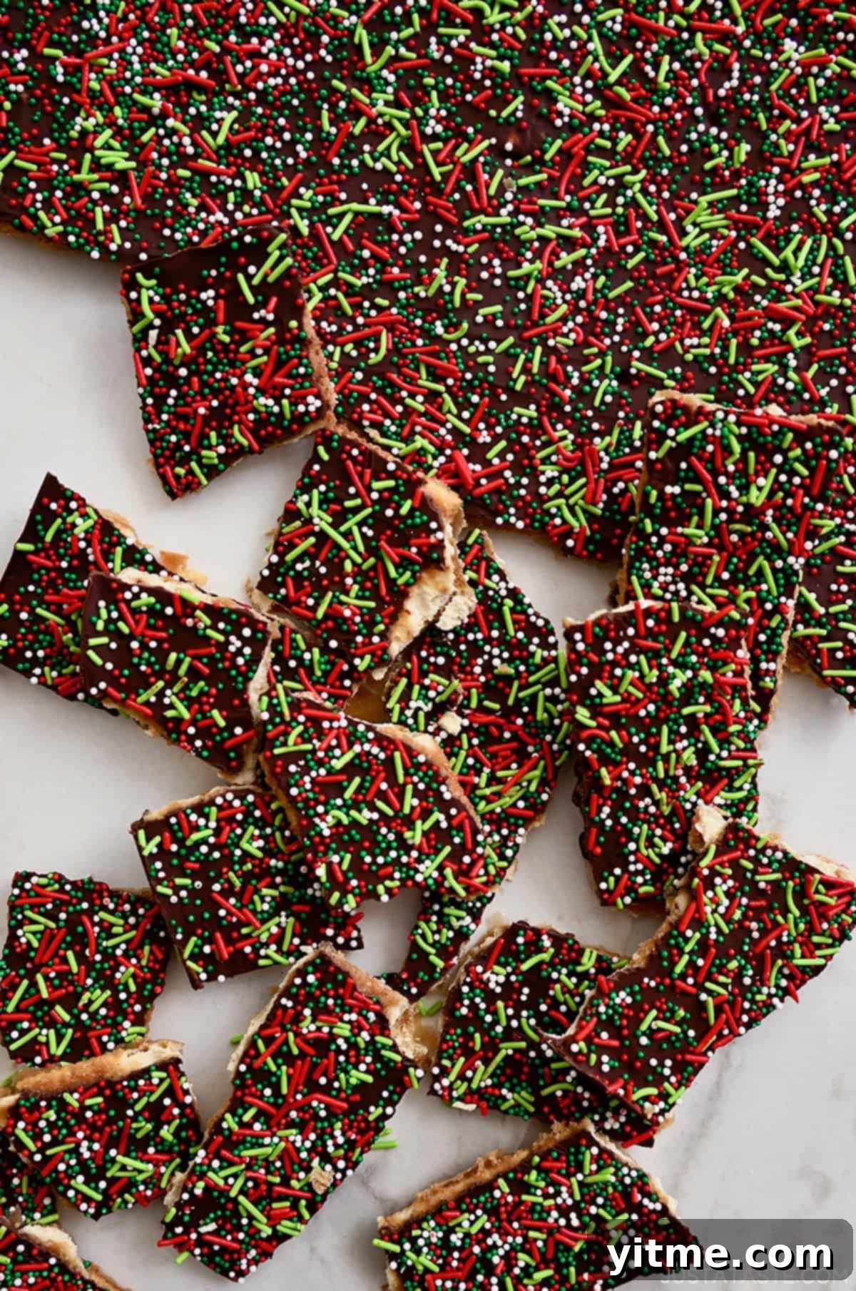 Broken apart Christmas Crack (Saltine Cracker Toffee) topped with red, green, and white sprinkles