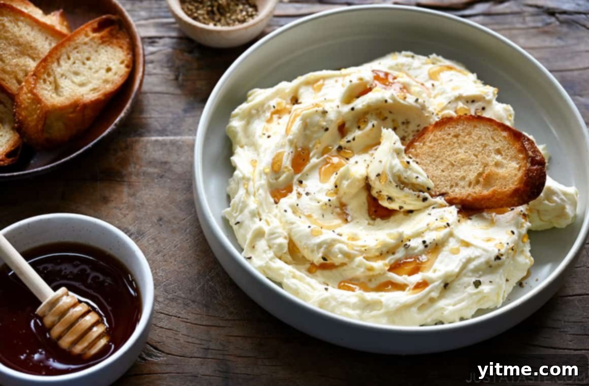 A bowl of whipped Brie cheese with a toast and a bowl of honey next to it