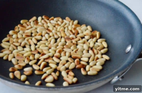 Toasted pine nute in a sauté pan