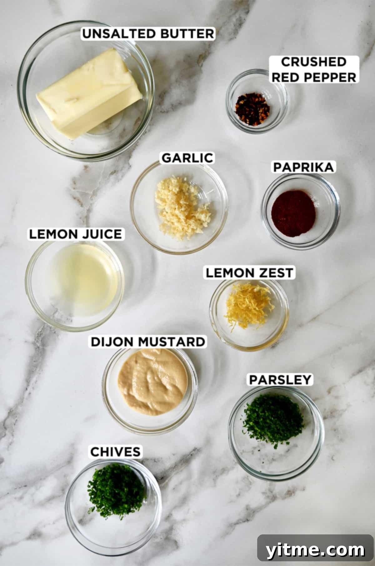 Cowboy Spice Infusion Butter 3 Ingredients for making cowboy butter, including butter, garlic, red pepper flakes, paprika, lemon, mustard, parsley, and chives.