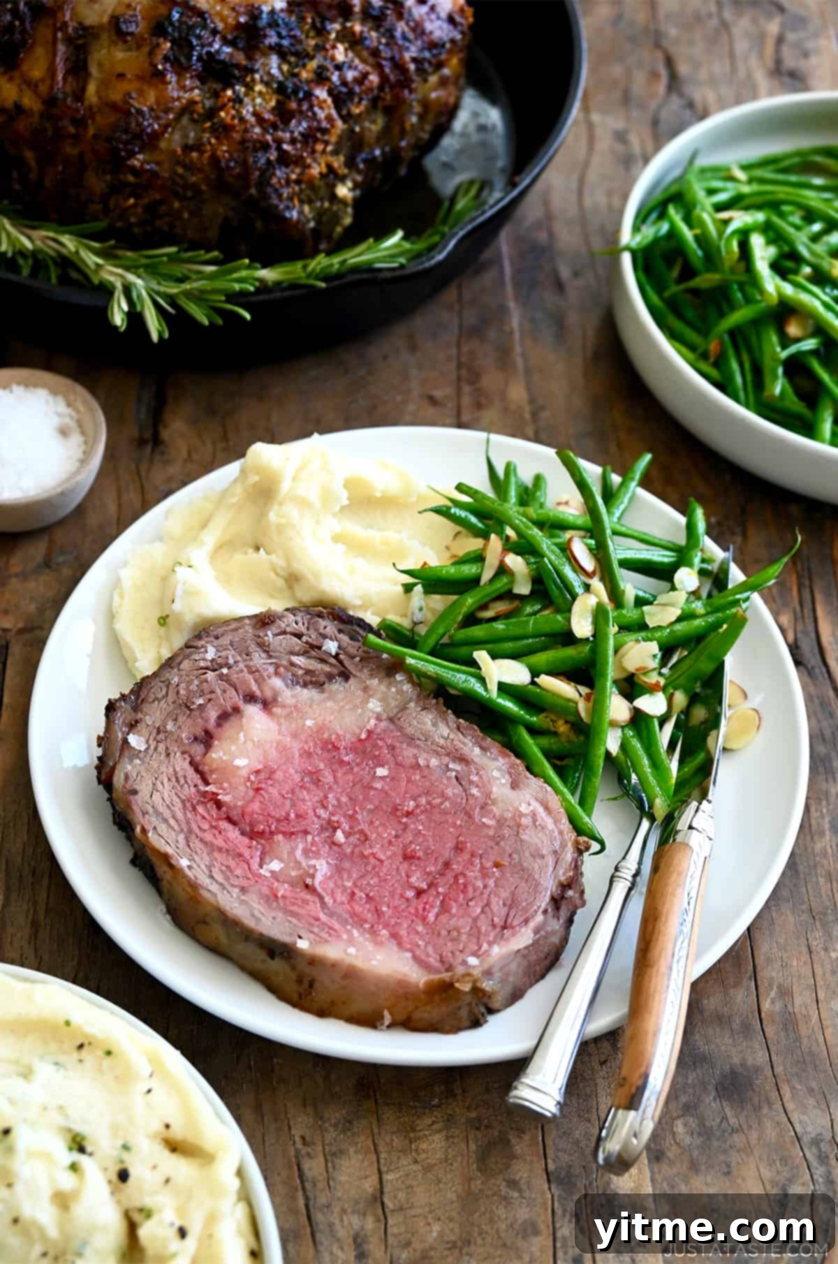 Perfectly cooked medium-rare prime rib served with green beans and mashed potatoes.