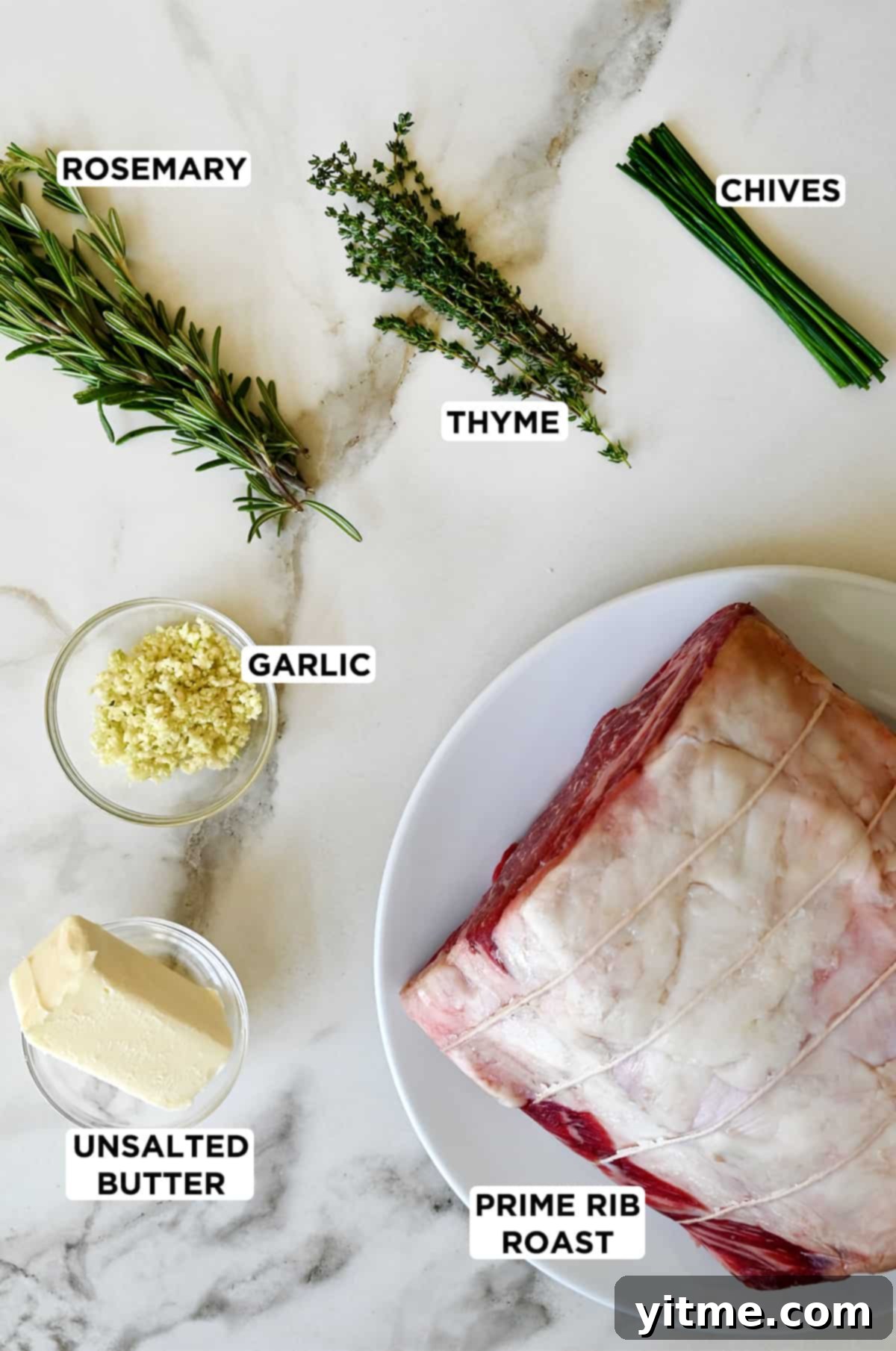 Ingredients for garlic herb prime rib: prime rib roast, butter, garlic, chives, rosemary, and thyme.