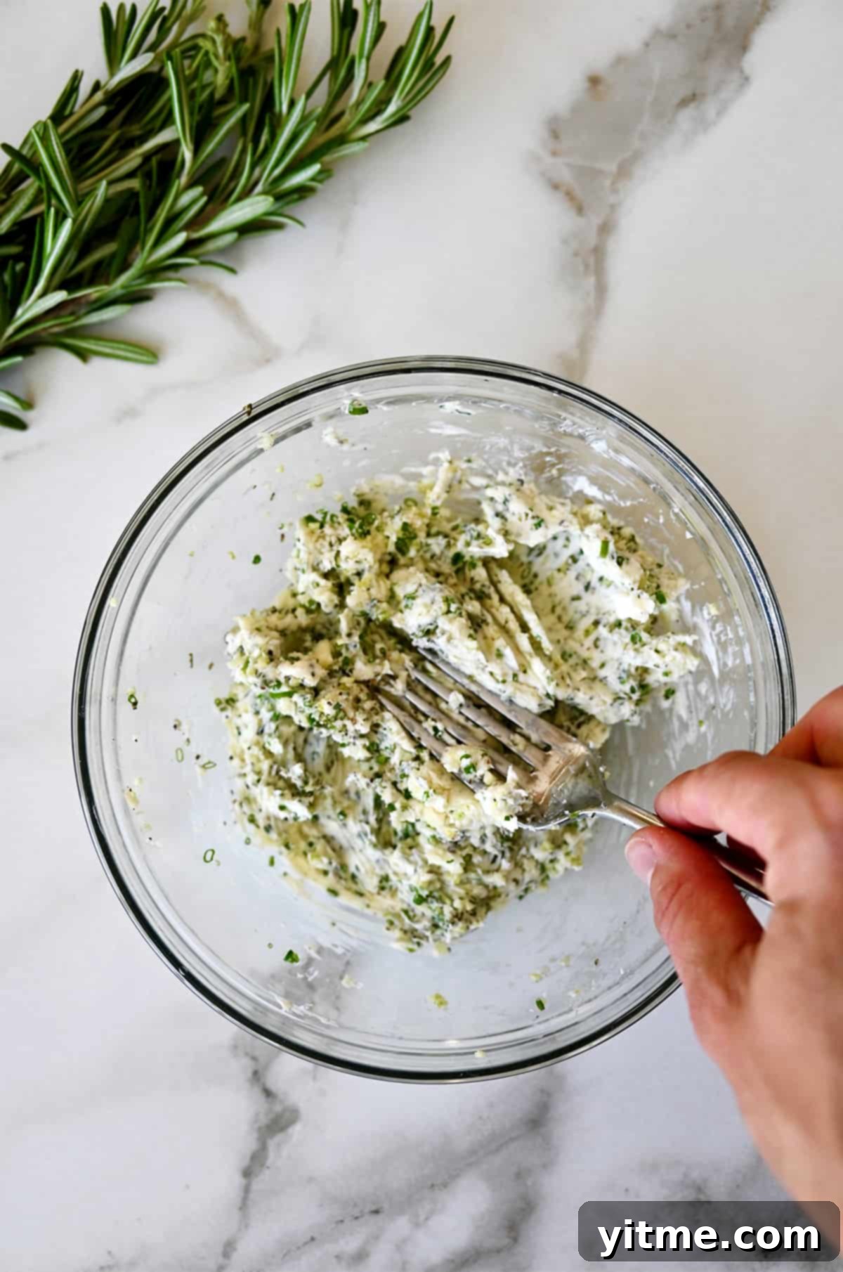 Mixing softened butter with garlic and herbs to create the flavor packed base for a prime rib.