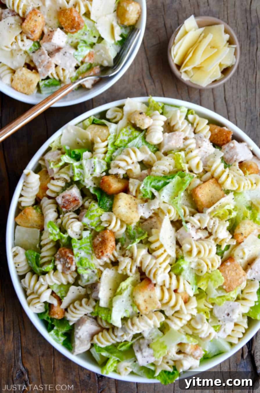 A large, vibrant bowl brimming with the best Chicken Caesar Pasta Salad, featuring crisp romaine, tender chicken, and pasta.