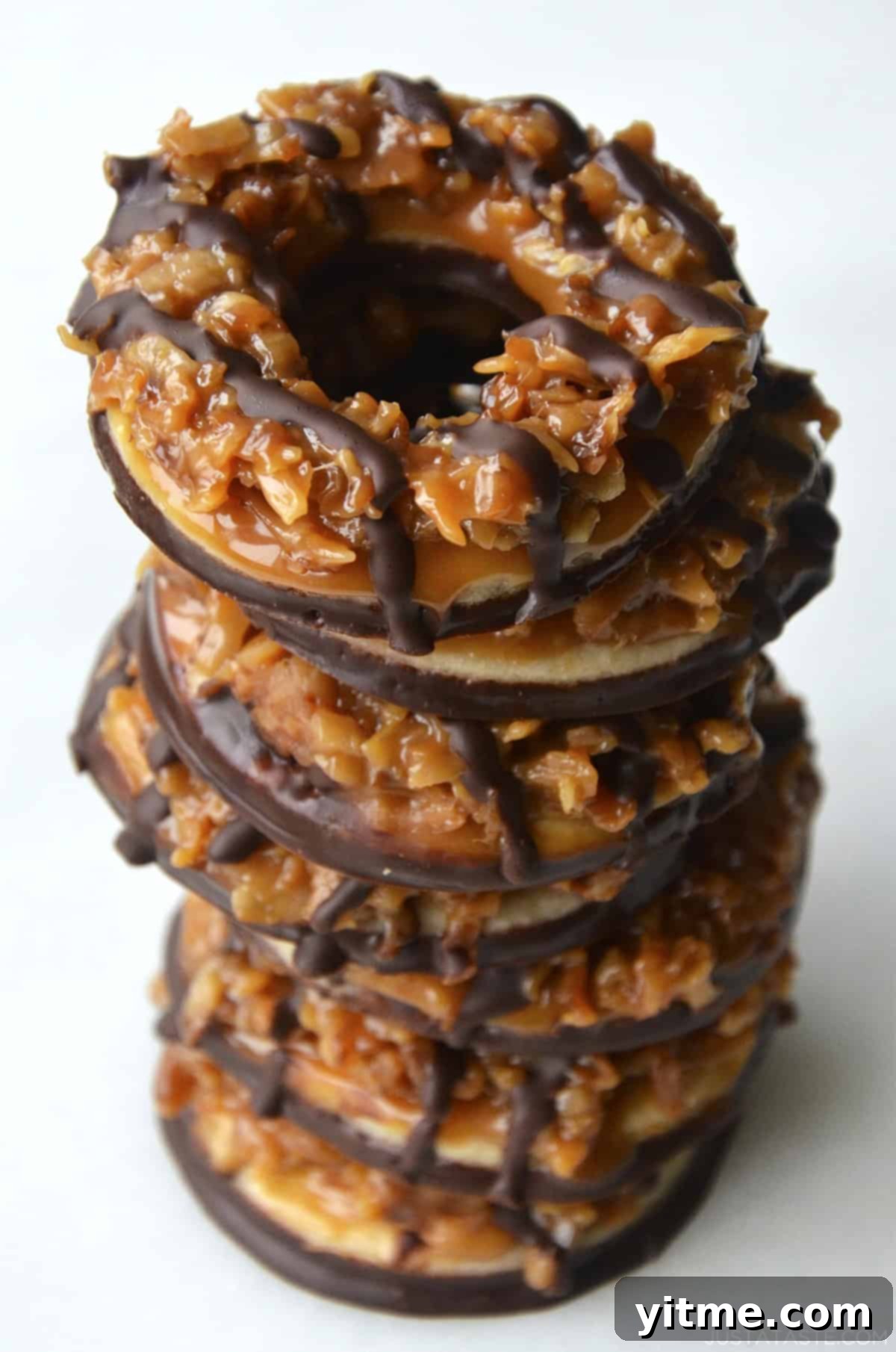 A stack of seven perfectly crafted homemade Samoas cookies, showcasing their iconic caramel, toasted coconut, and chocolate drizzle.