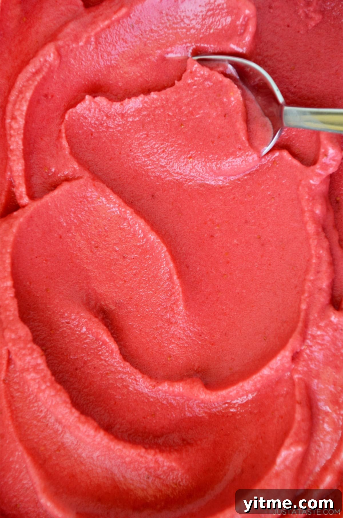 A refreshing bowl of creamy, healthy strawberry frozen yogurt, garnished with fresh strawberries.
