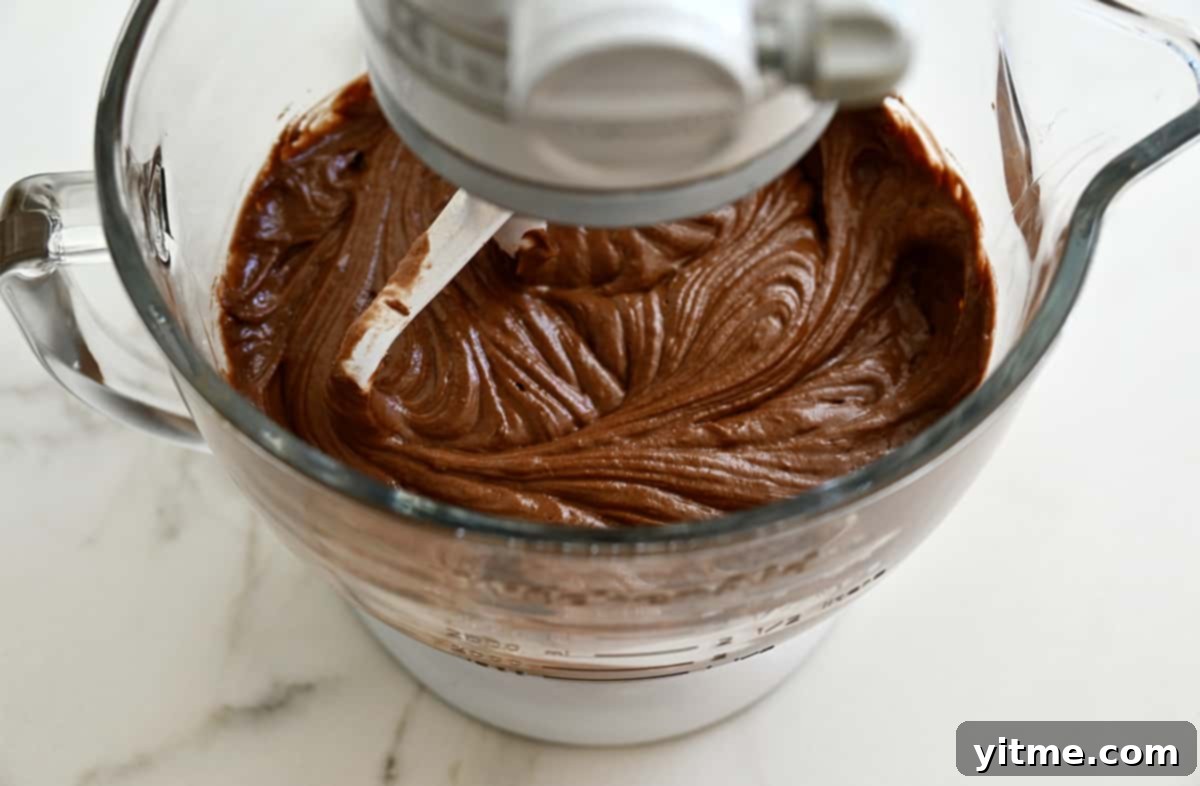 Chocolate cupcake batter in the bowl of a stand mixer fitted with the paddle attachment.