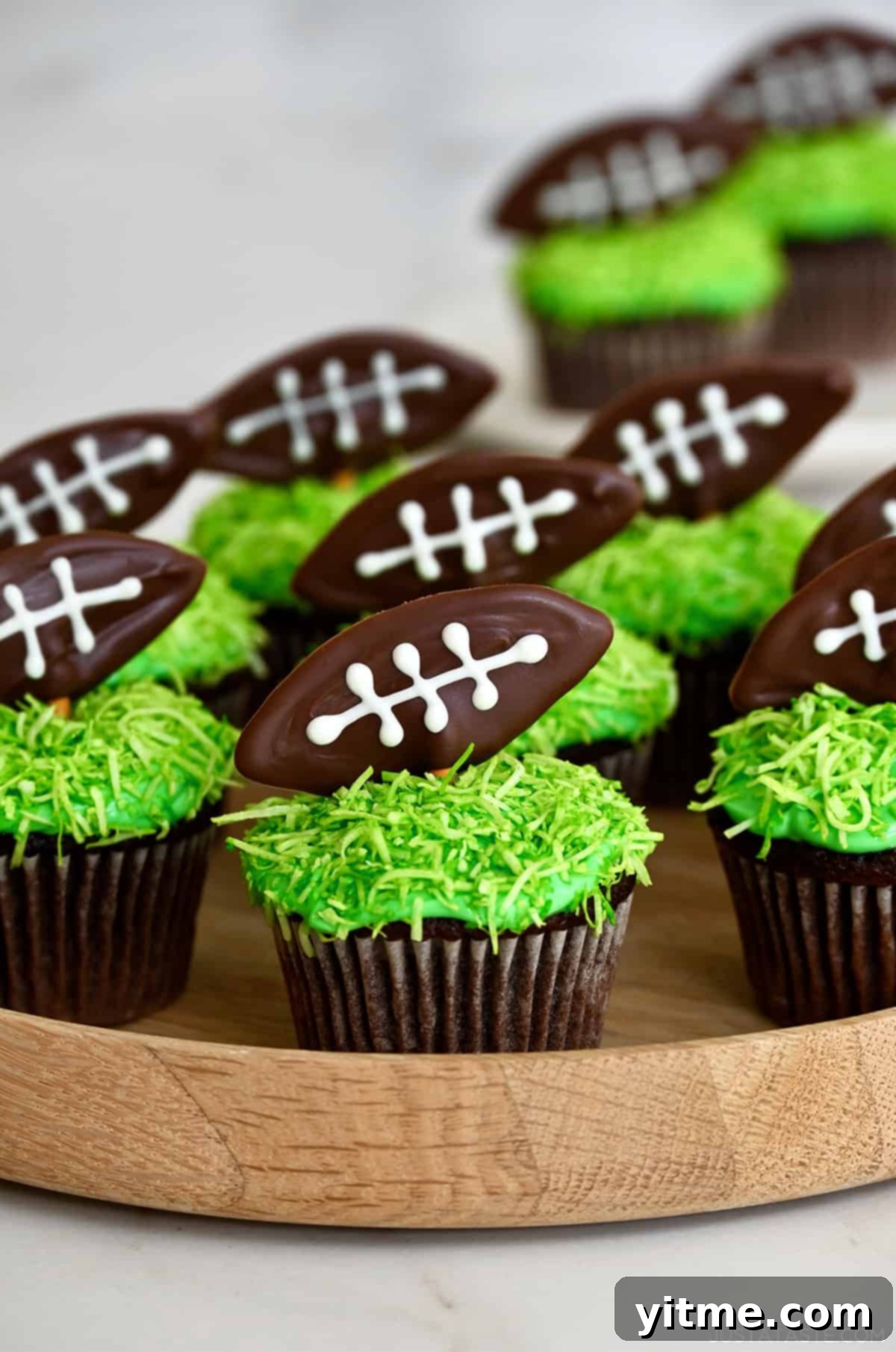 Chocolate cupcakes topped with coconut and chocolate footballs