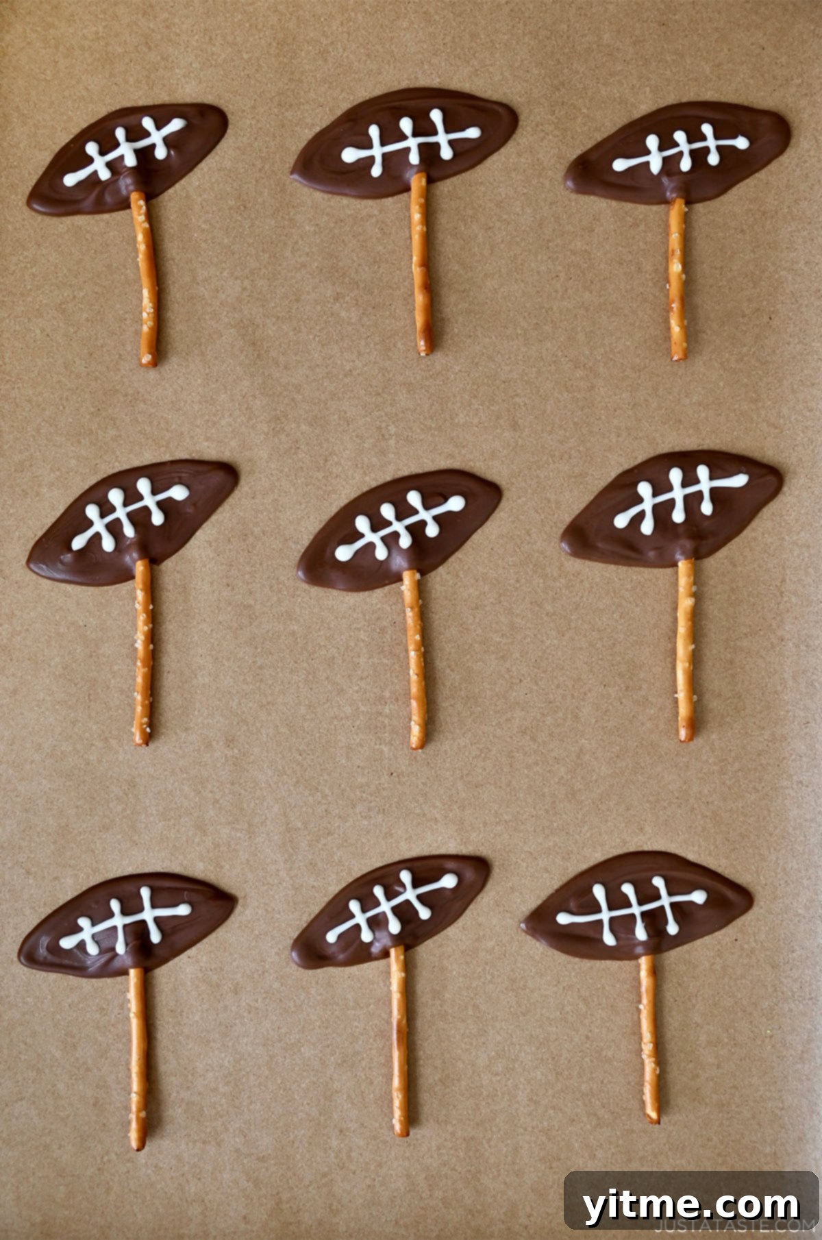 Chocolate footballs piped onto pretzel sticks
