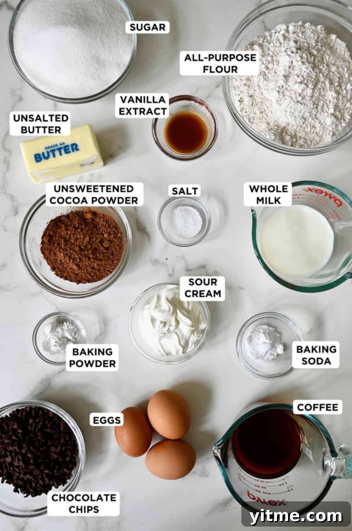 Chocolate cake ingredients in various sizes of glass bowls.