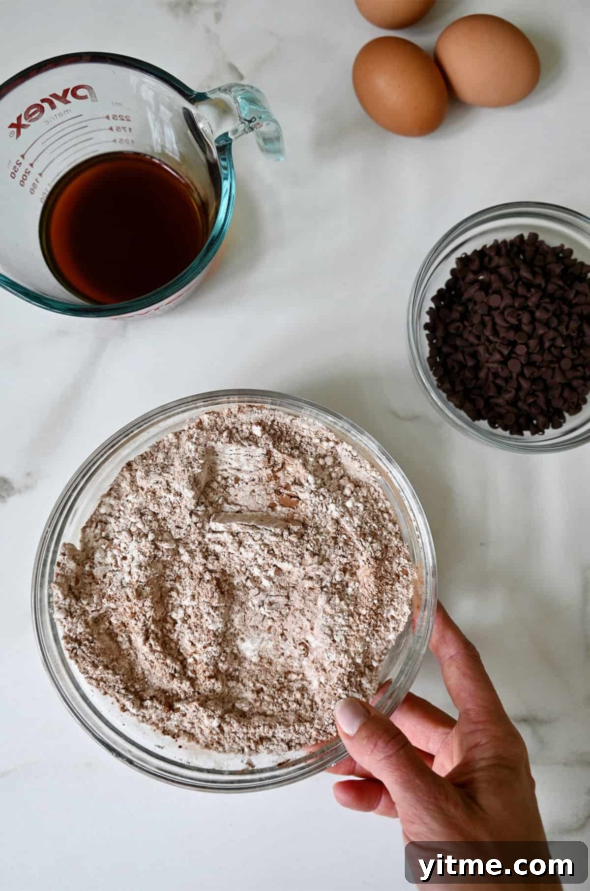 A medium bowl containing dry cake mix ingredients.