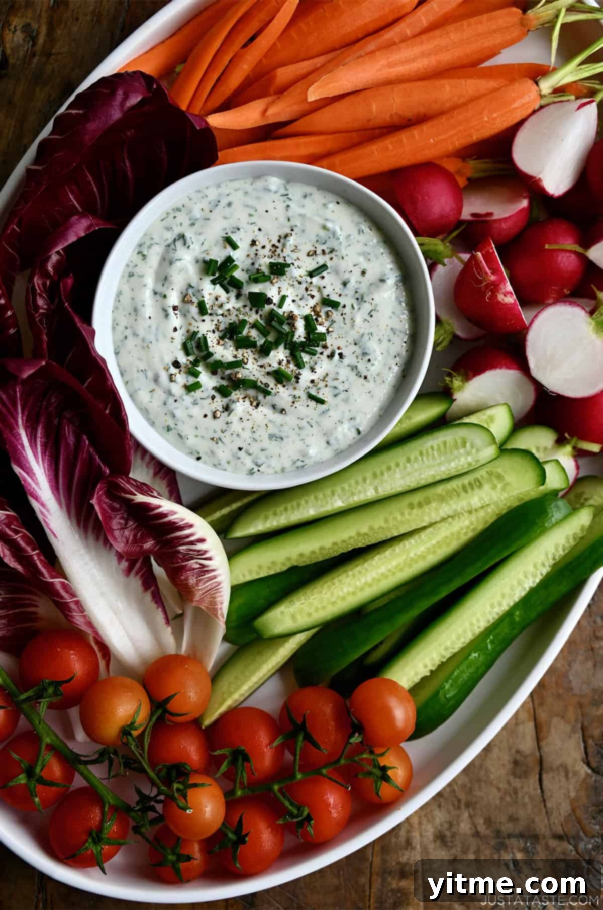 Cottage cheese veggie dip in a bowl on a platter surrounded by fresh veggies.