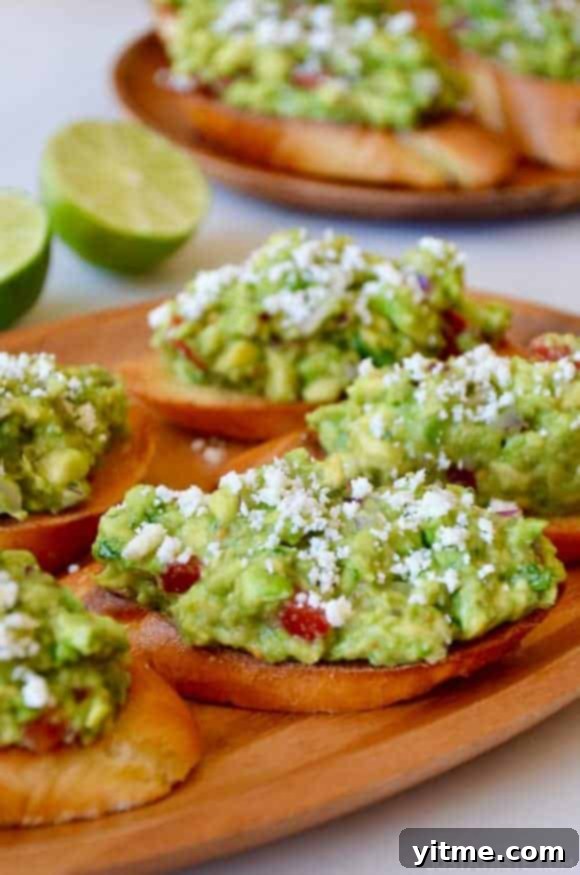 Guacamole bruschetta toasts on a wooden plate