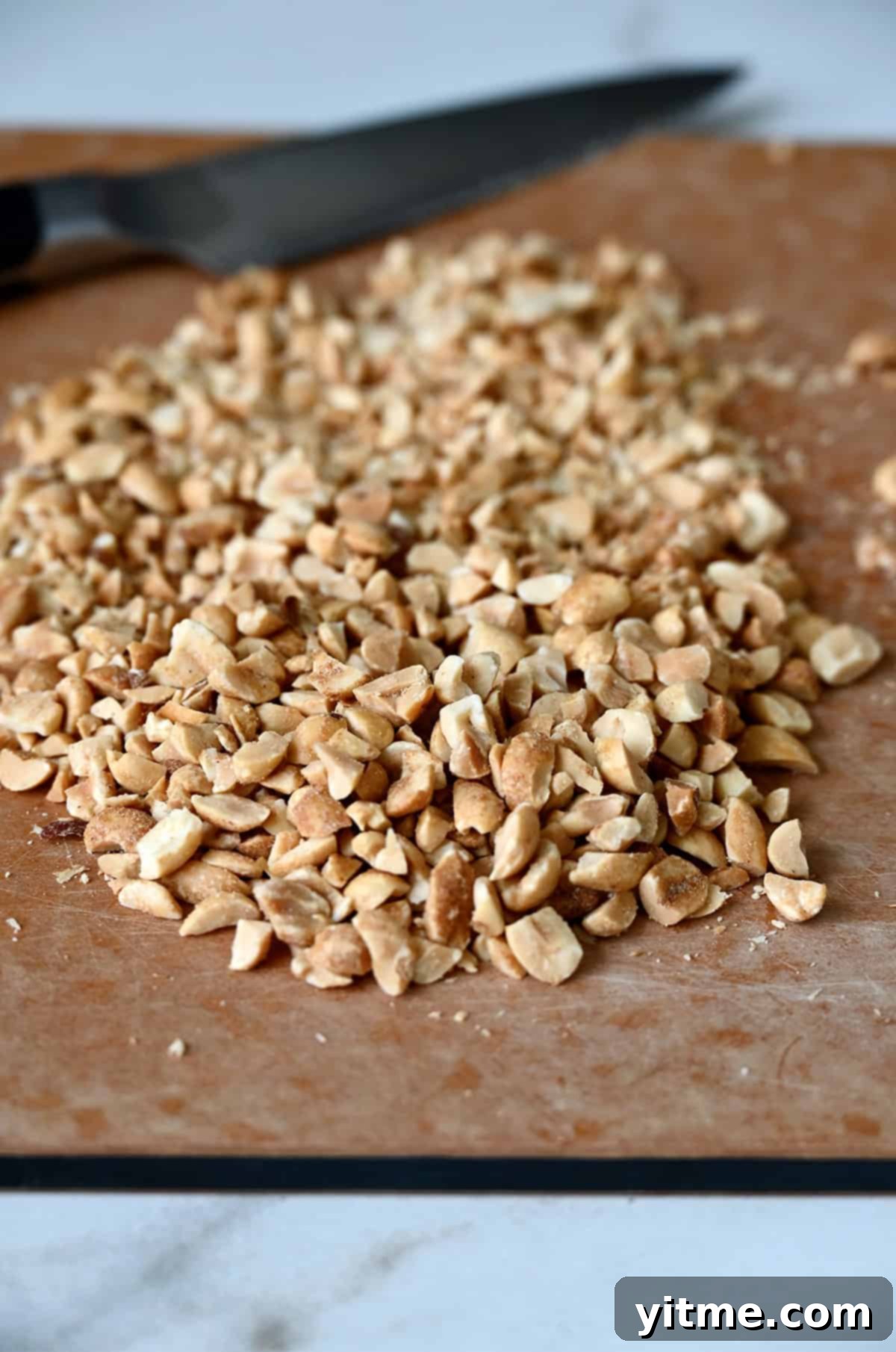 Chopped peanuts on a cutting board with a knife