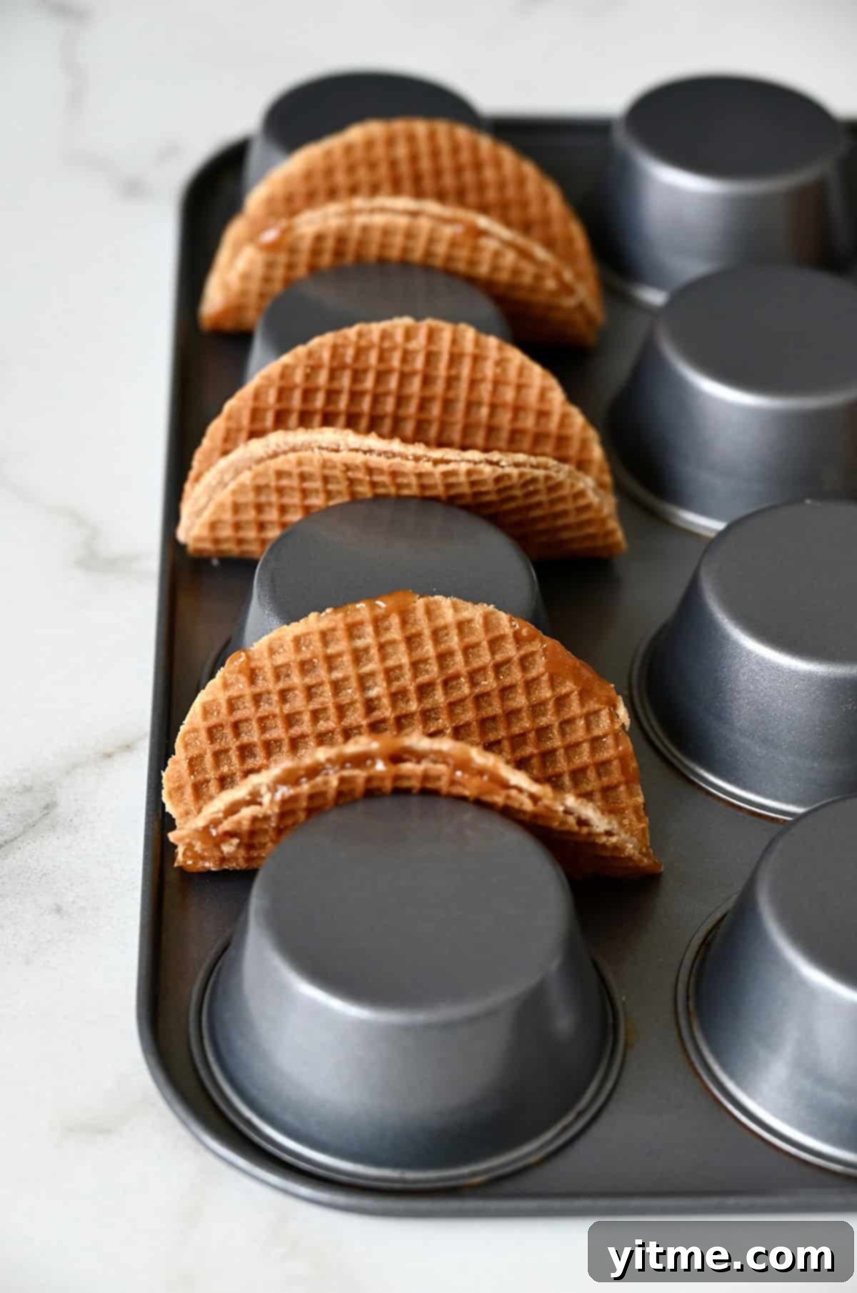 Stroopwafels in a taco shape on an inverted muffin pan