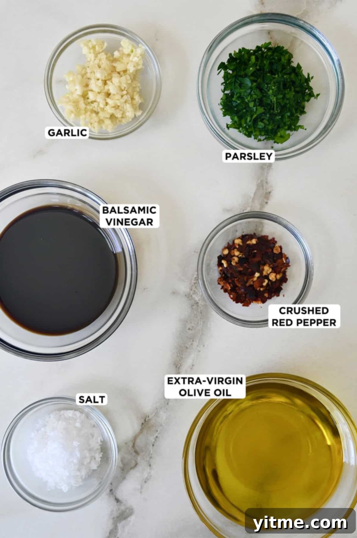 Ingredients for bread dipping oil: olive oil, balsamic vinegar, garlic, parsley, red pepper flakes, and sea salt