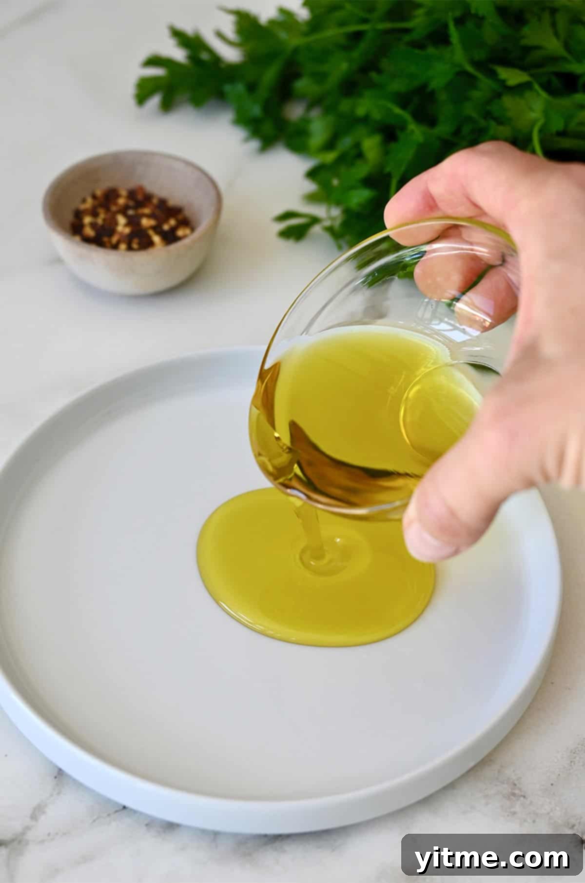 Olive oil being poured into a shallow plate