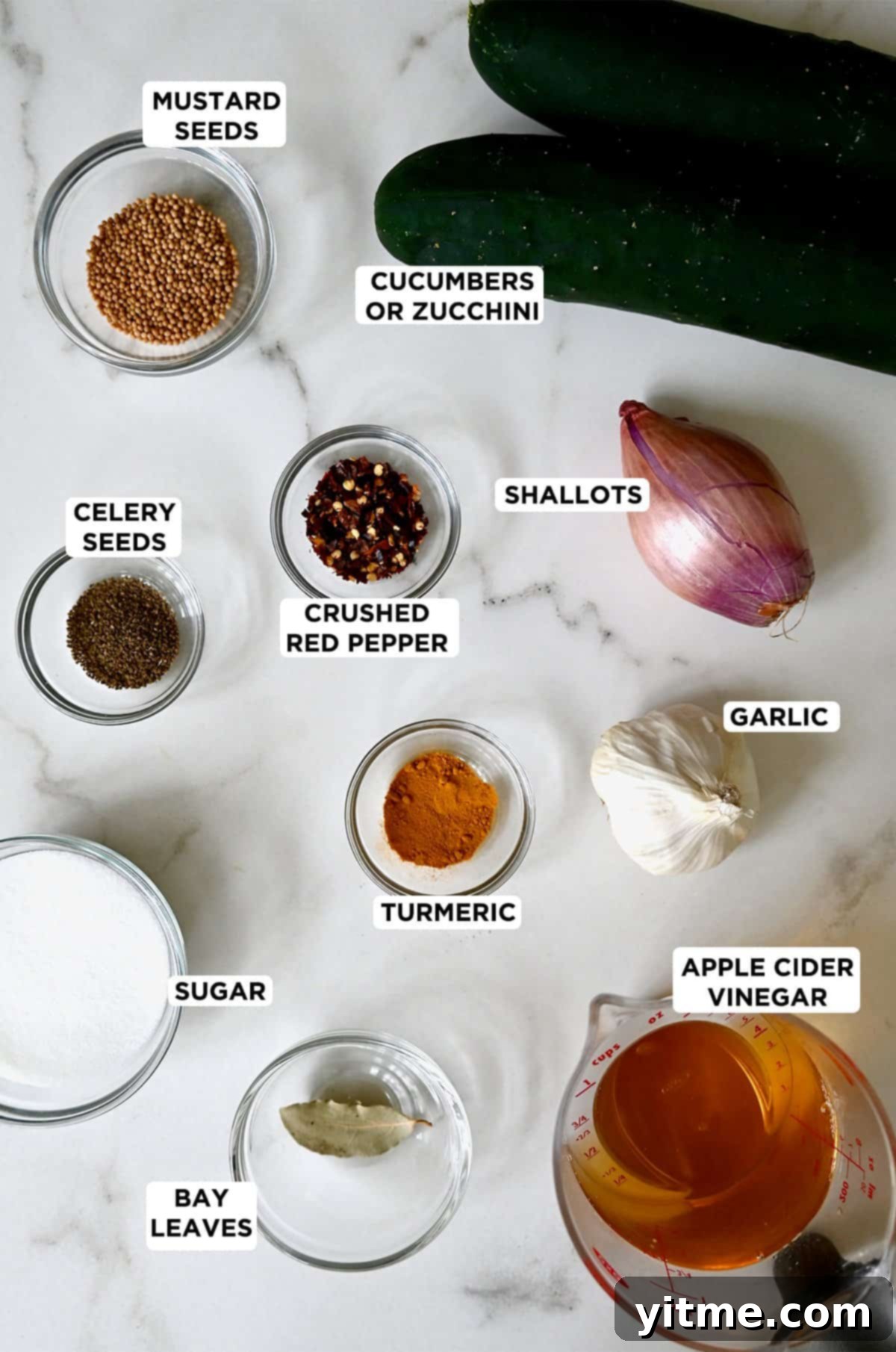 Zucchini bread and butter pickle ingredients, including zucchini, apple cider vinegar, sugar, shallots, garlic, mustard seed, turmeric, and celery seed.