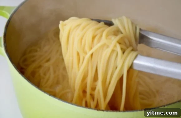 Cacio e Pepe: The Quintessential Roman Comfort Food 3 Close-up of cooked spaghetti in a green pot