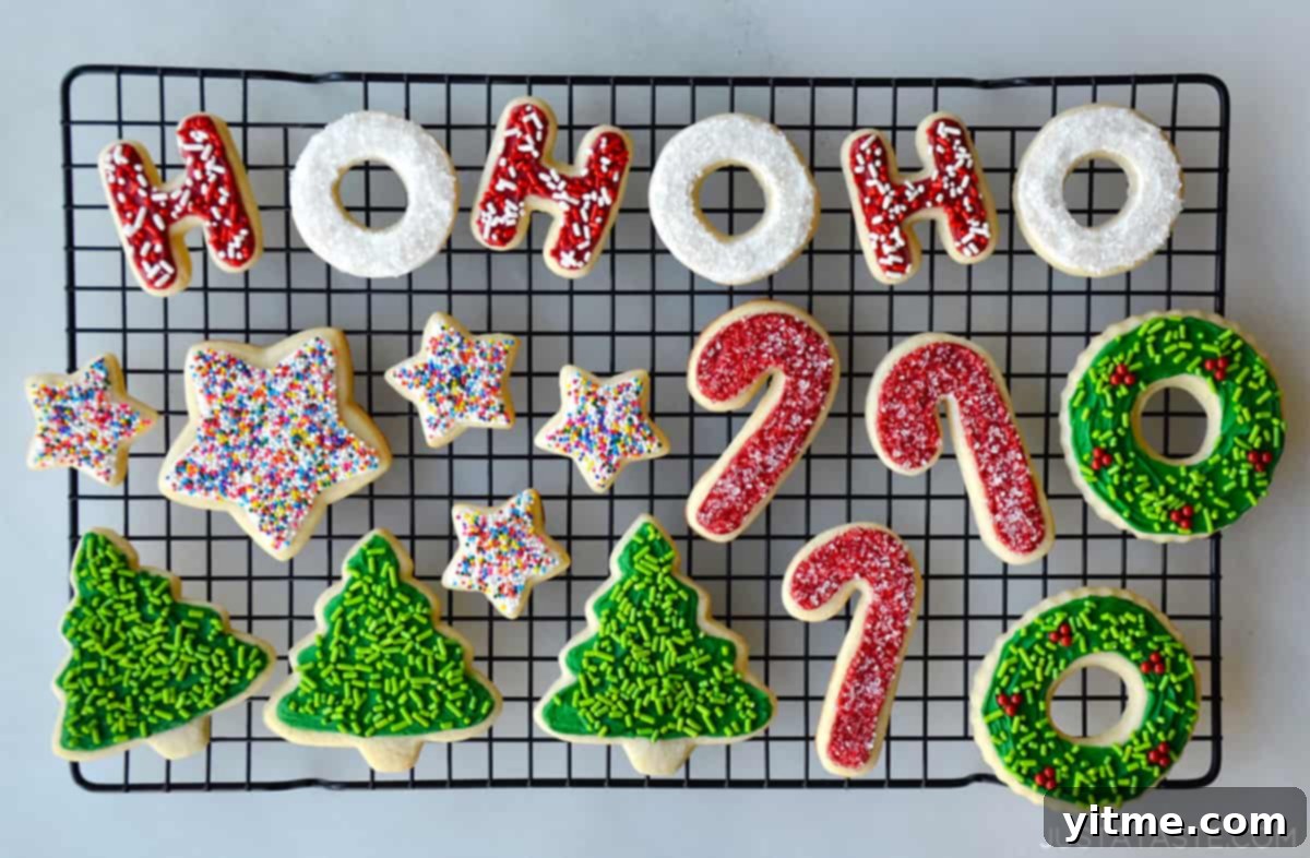 Christmas-themed sugar cookies with red, green, and white frosting and sprinkles on a wire cooling rack.