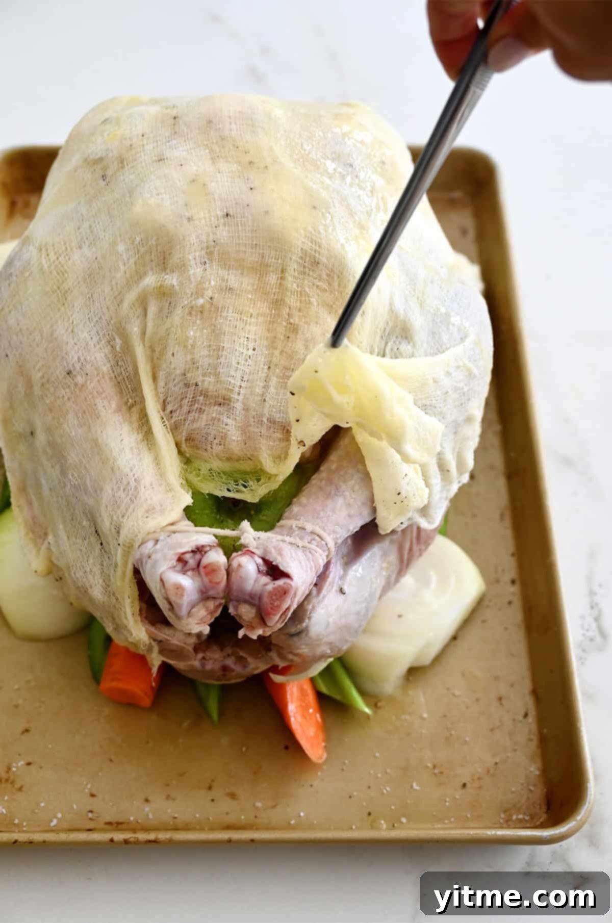 A butter-soaked cheesecloth draped over a turkey before going into the oven to roast, creating a self-basting effect.