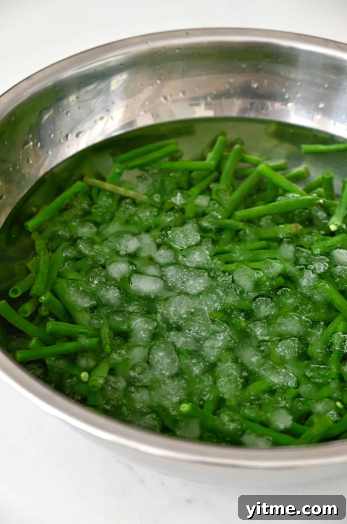Blanched green beans in ice water to stop cooking and preserve color.